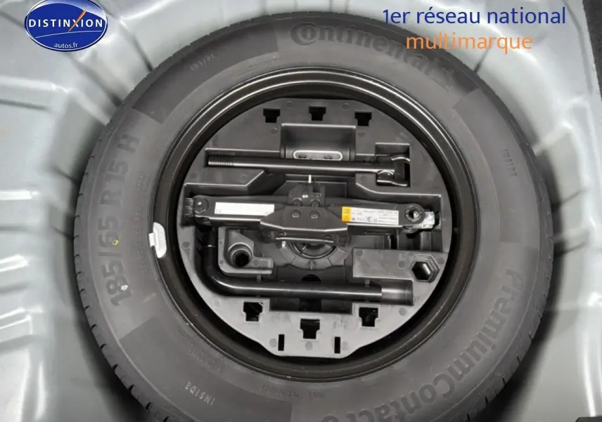 Roue de secours avec outillage intégré dans le coffre d'une Renault Clio V gris schiste, vue de dessus.