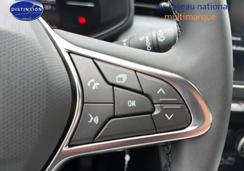 Gros plan sur les commandes multifonctions noires du volant de la Renault Clio V gris schiste, côté gauche.
