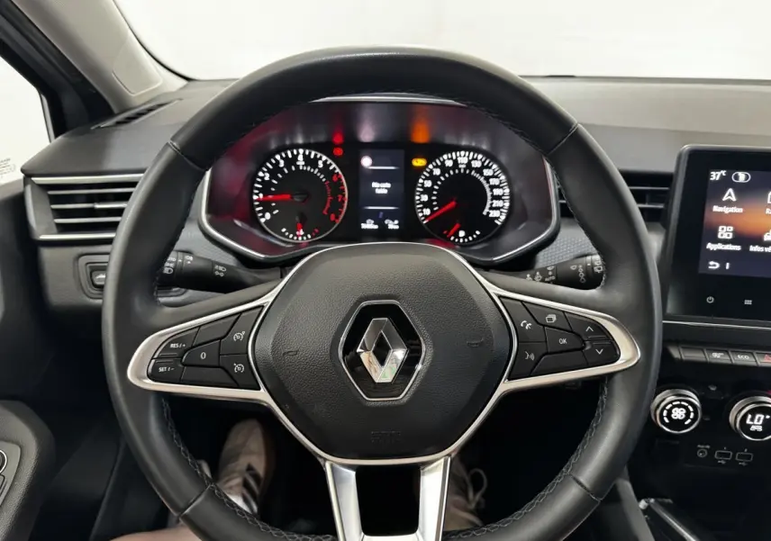 Vue intérieure centrée sur le volant cuir noir de la Renault Clio 2020 avec tableau de bord et écran tactile visibles.