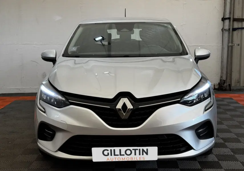 Vue frontale d'une Renault Clio Business TCe 90 gris clair avec feux LED allumés dans un garage.