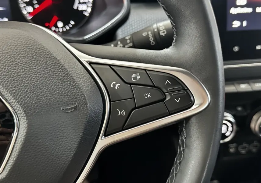 Gros plan sur les commandes multifonctions en cuir noir du volant côté droit de la Renault Clio gris clair 2020.