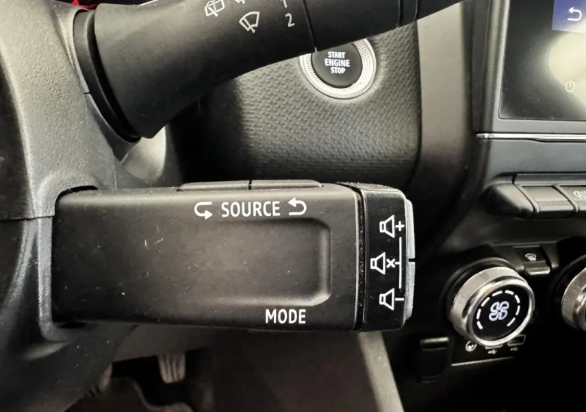 Gros plan sur la commande au volant gauche d’une Renault Clio Business TCe 90 2020, avec bouton source et mode.