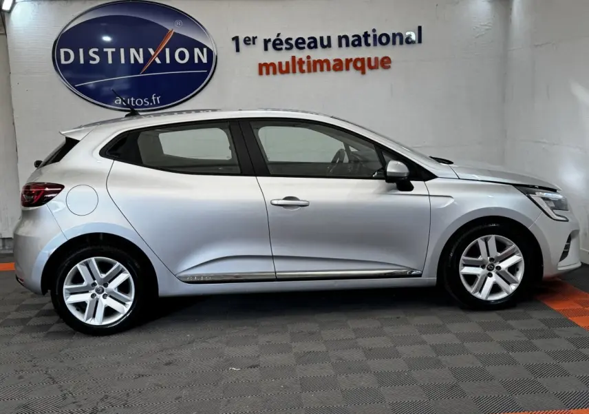 Profil côté gauche d'une Renault Clio Business TCe 90 gris clair 2020, avec jantes alliage et poignées de porte chromées.