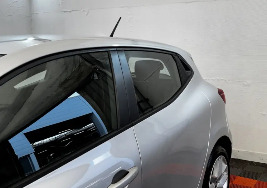 Vue latérale côté droit d'une Renault Clio Business TCe 90 gris clair, mettant en valeur la porte arrière et la ligne de caisse fluide.