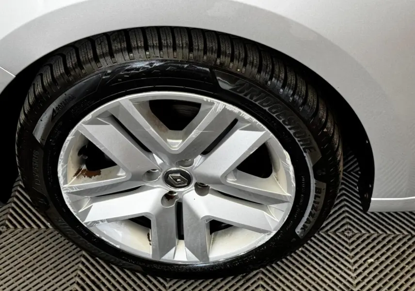 Gros plan sur la roue avant droite gris clair d’une Renault Clio Business TCe 90 avec jante alliage et pneu Bridgestone.