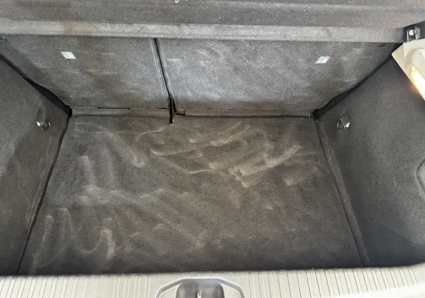 Vue plongeante sur le coffre vide gris foncé de la Renault Clio Business TCe 90 de 2020, avec banquette rabattue.