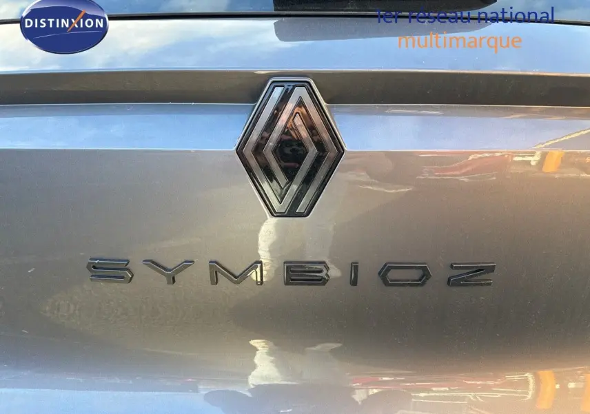Gros plan sur le logo Renault et le nom Symbioz en gris cassiopée métal sur la partie arrière du véhicule.