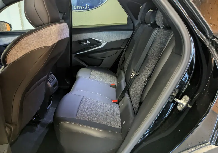 Vue latérale intérieure côté droit des sièges arrière en tissu gris et cuir noir du Peugeot 3008 Hybrid 145 Allure 2025 noir.