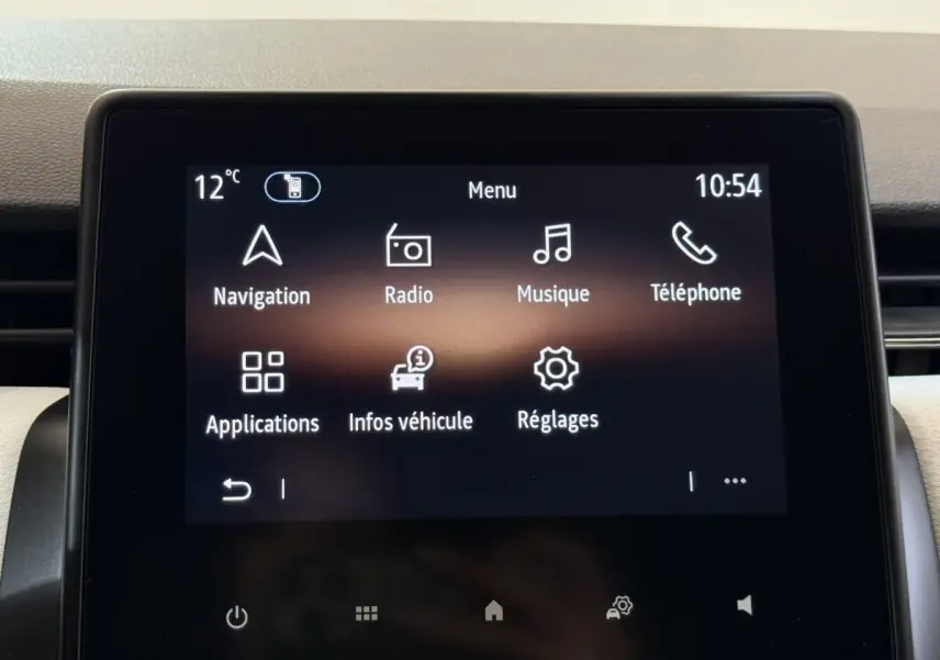 Écran tactile central de la Renault Clio blanc 2023 affichant le menu principal avec navigation et radio.