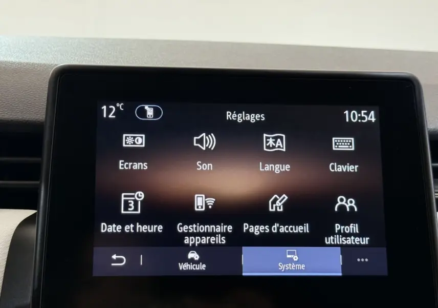 Écran tactile central de la Renault Clio blanc, affichant le menu Réglages avec icônes claires.