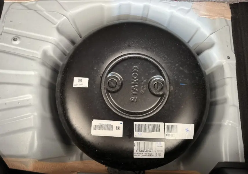 Réservoir GPL noir circulaire dans le coffre d'une Renault Clio blanche Evolution TCe 100 GPL 2023.