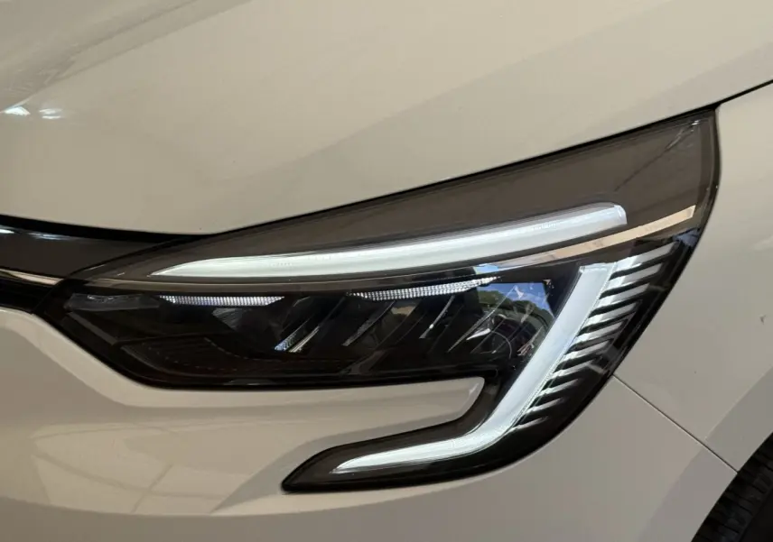 Gros plan sur le phare avant droit LED d’une Renault Clio blanche Evolution TCe 100 GPL 2023.