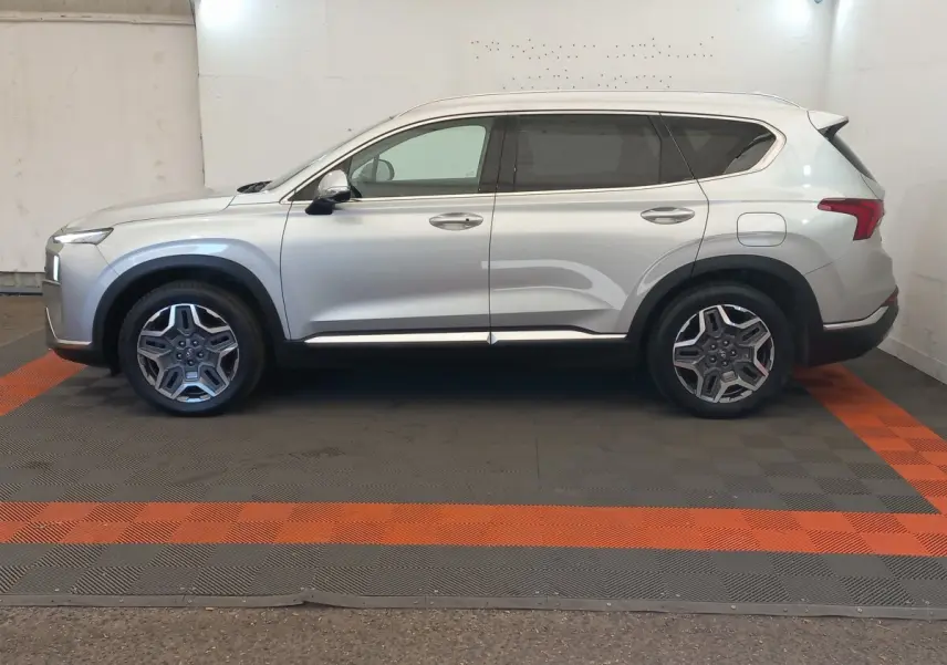 Vue latérale droite d’un Hyundai Santa Fe gris clair 2022 avec jantes alliage et lignes épurées.