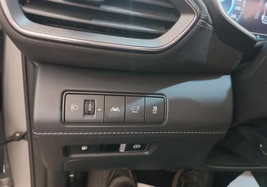 Détail du tableau de bord côté gauche du Hyundai Santa Fe gris clair, avec commandes d’éclairage et aides à la conduite.