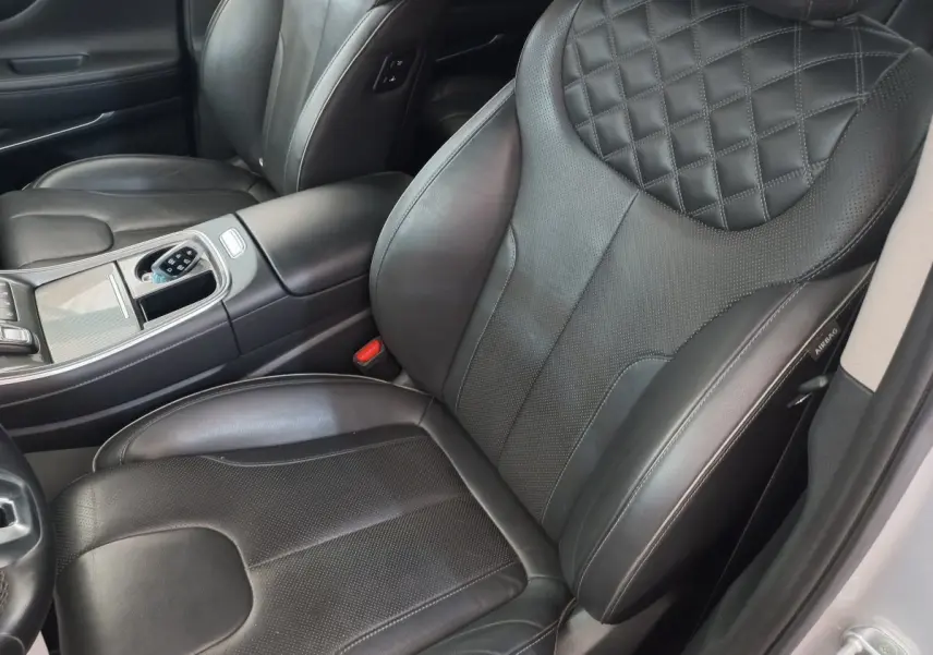 Gros plan sur les sièges avant en cuir noir matelassé du Hyundai Santa Fe gris clair, avec console centrale visible.