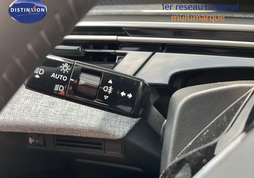 Gros plan sur la commande des feux et clignotants du Peugeot 3008 Hybrid gris Artense, intérieur tissu gris.