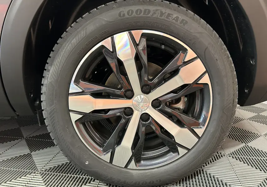 Gros plan sur la jante alliage bicolore du Peugeot 5008 Gris Platinium avec pneu Goodyear visible au sol.