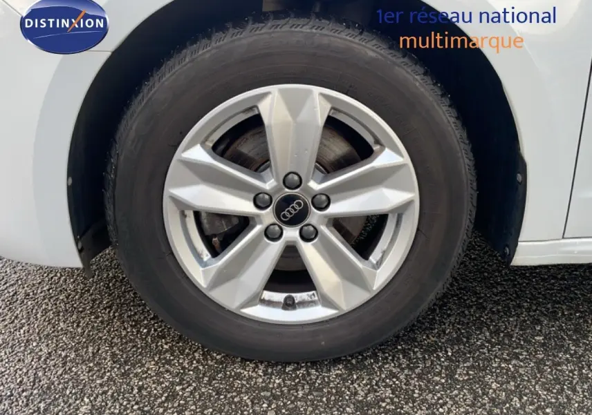 Gros plan sur la commande de régulateur de vitesse à gauche du volant dans l'Audi A1 Sportback blanc glacier 2023.