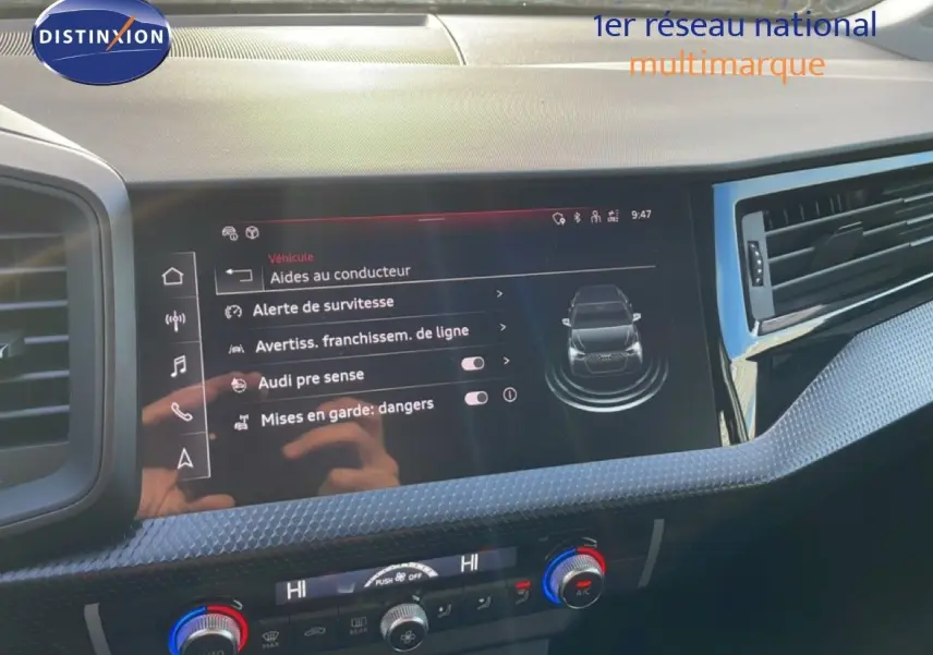 Vue rapprochée de la console centrale d'une Audi A1 Sportback blanche, montrant les commandes et ports USB.