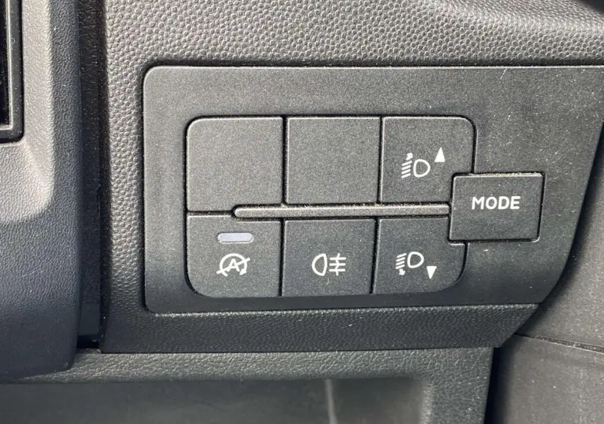 Panneau de commandes intérieures noires avec boutons de réglage des phares et mode sur Opel Movano Fourgon blanc.
