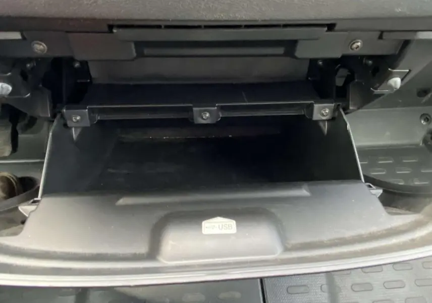 Gros plan sur la boîte à gants ouverte avec port USB visible dans l'habitacle d'un Opel Movano blanc.