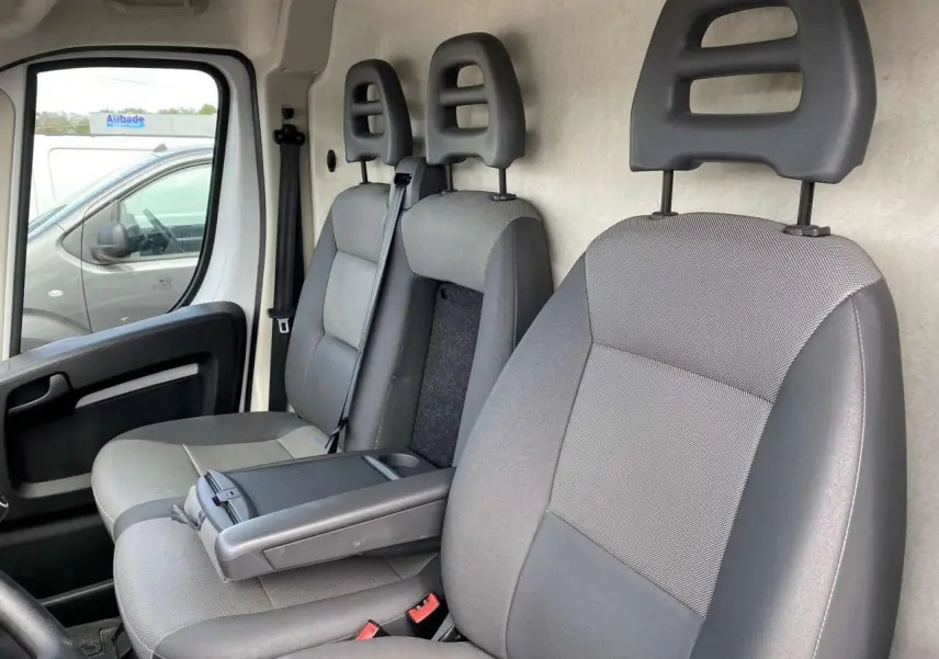 Vue intérieure côté gauche montrant les sièges avant gris du fourgon Opel Movano 2022 avec accoudoir conducteur.