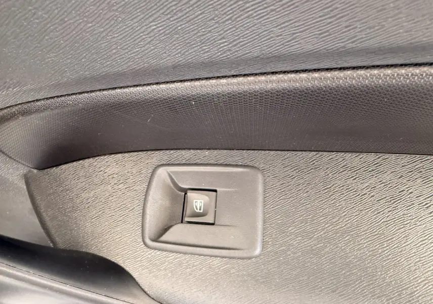 Gros plan sur le bouton de commande de la vitre électrique côté conducteur du Renault Kangoo blanc, intérieur noir.