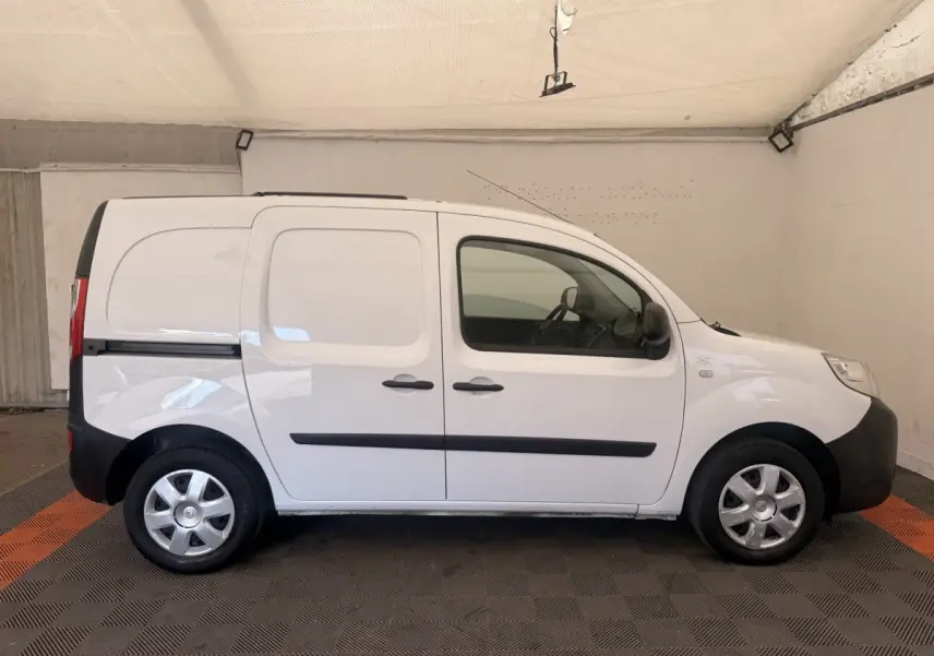 Profil droit d’un Renault Kangoo blanc 2016, utilitaire compact avec portes latérales et jantes acier.
