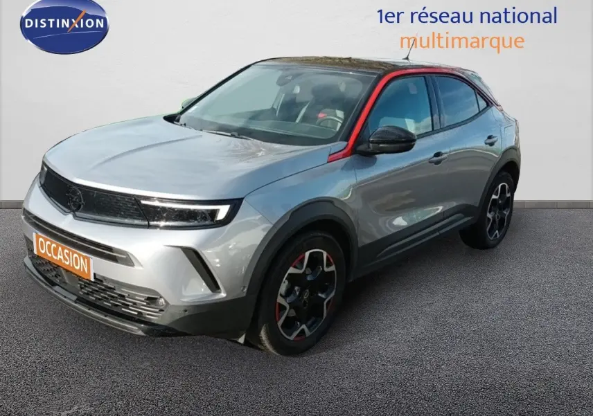 Opel Mokka GS Line gris quartz en 3/4 avant droit avec toit noir et détails rouges sur les jantes et montant de porte.