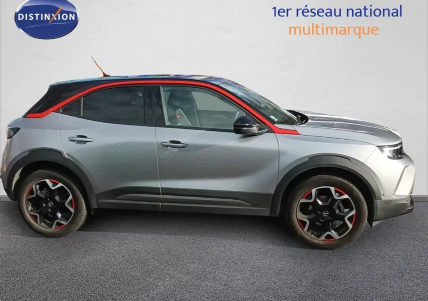 Opel Mokka GS Line 2022 gris quartz en profil droit avec toit et détails rouges contrastants et jantes noires bicolores.