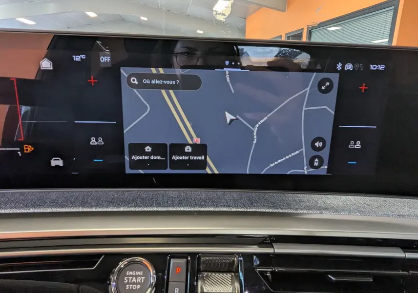 Vue rapprochée de l’écran tactile central du tableau de bord du Peugeot 3008 blanc, affichant la navigation GPS.