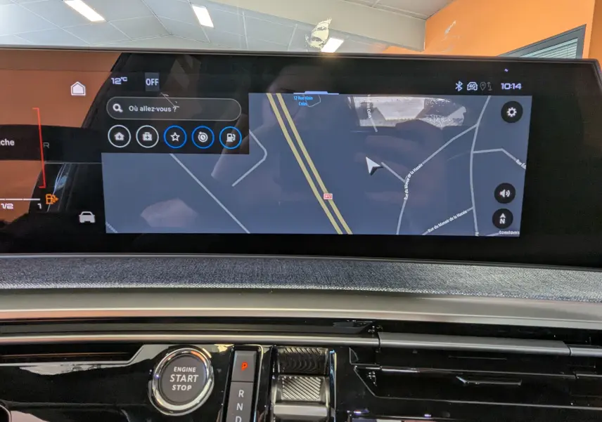 Vue rapprochée du tableau de bord noir du Peugeot 3008 1.2 Hybrid avec écran tactile affichant la navigation.