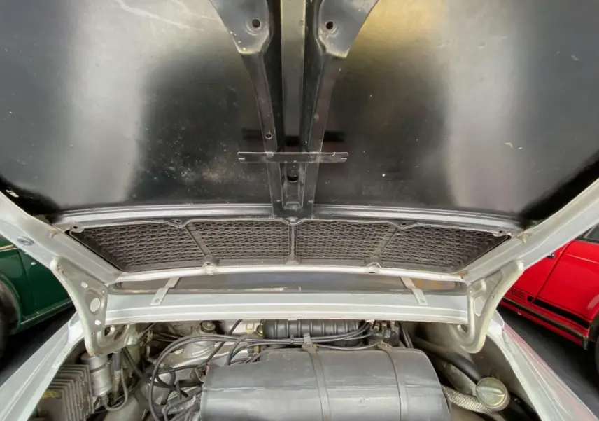 Vue plongeante sur le moteur gris d'une Porsche 911 3.0 SC 930 Kg, capot arrière ouvert en gris métallisé.