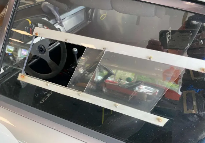 Vue intérieure côté gauche d’une Porsche 911 3.0 SC grise, montrant le volant Sparco et les baquets course.