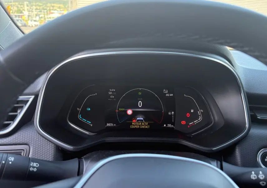 Vue rapprochée du tableau de bord numérique de la Renault Clio 1.6 E-TECH gris foncé, affichant les informations de conduite.