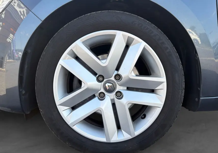 Gros plan sur la jante alliage argentée avec logo Renault, roue avant droite d'une Clio gris foncé 2021.