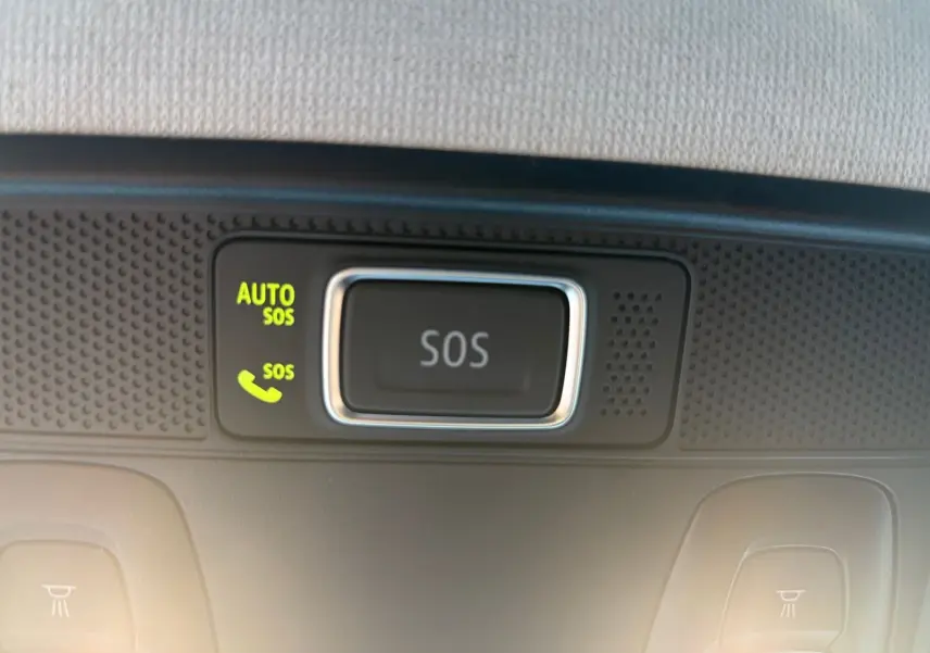 Bouton SOS lumineux sur le plafonnier intérieur de la Renault Clio gris foncé, vue en gros plan.