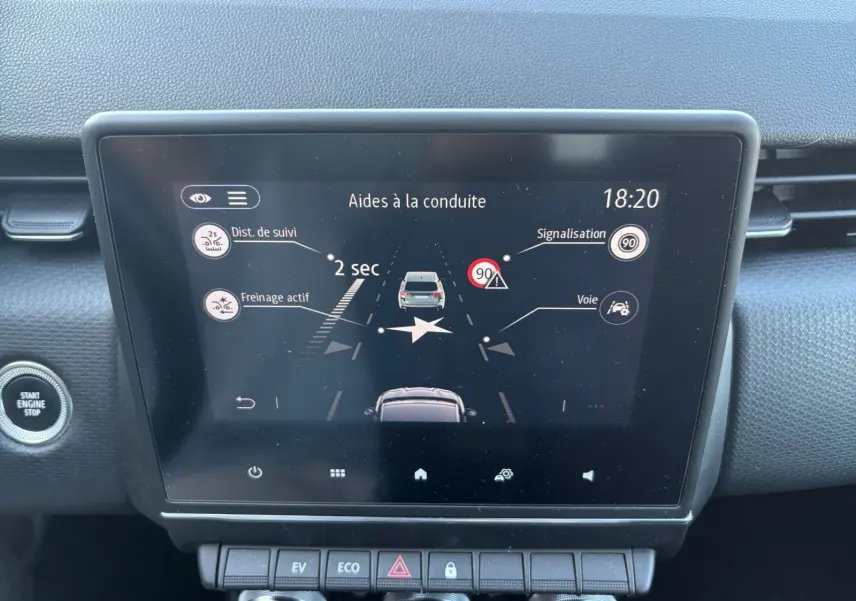 Écran tactile central de la Renault Clio 1.6 E-TECH Business 2021 montrant les aides à la conduite, bouton start/stop visible.