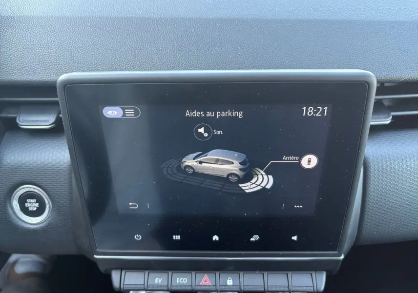 Écran tactile central d’une Renault Clio 1.6 E-TECH Business 2021 affichant l’aide au parking, avec bouton Start/Stop visible à gauche.