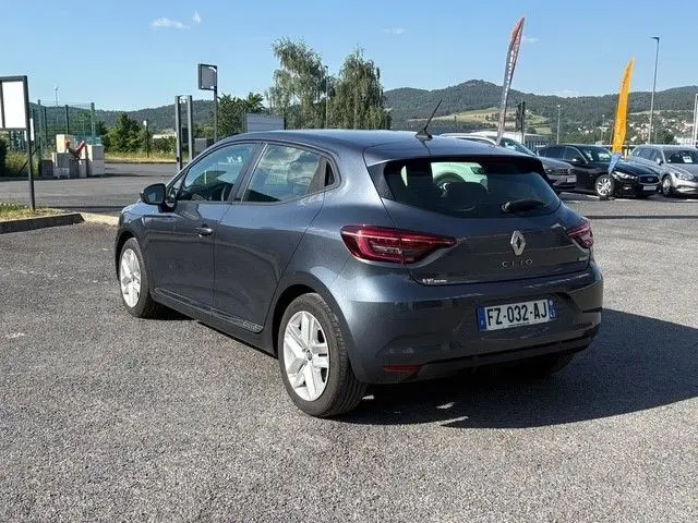 Renault Clio 1.6 E-TECH Business gris foncé vue 3/4 arrière droite sur parking ensoleillé avec feux LED éteints.