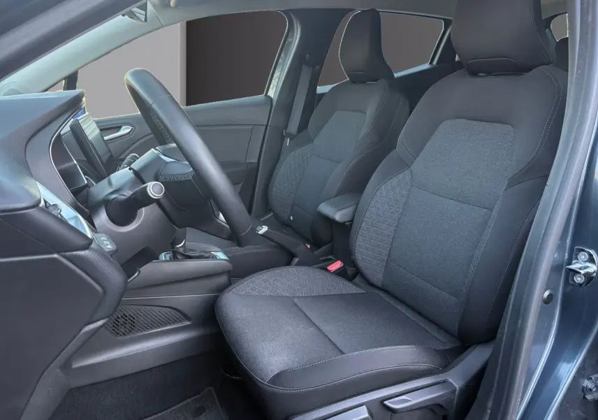 Vue intérieure côté conducteur de la Renault Clio 1.6 E-TECH Business 2021, sièges tissu gris foncé et tableau de bord moderne.