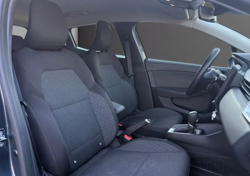 Vue intérieure côté conducteur de la Renault Clio 1.6 E-TECH Business 2021, sièges tissu gris foncé et tableau de bord moderne.