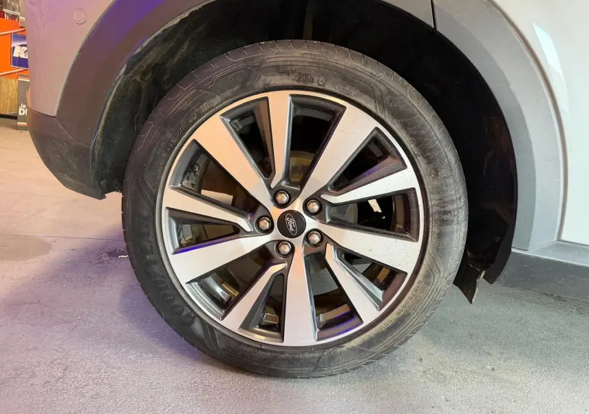 Gros plan sur la roue avant droite du Ford Puma gris 2021 avec jante alliage à cinq doubles branches.