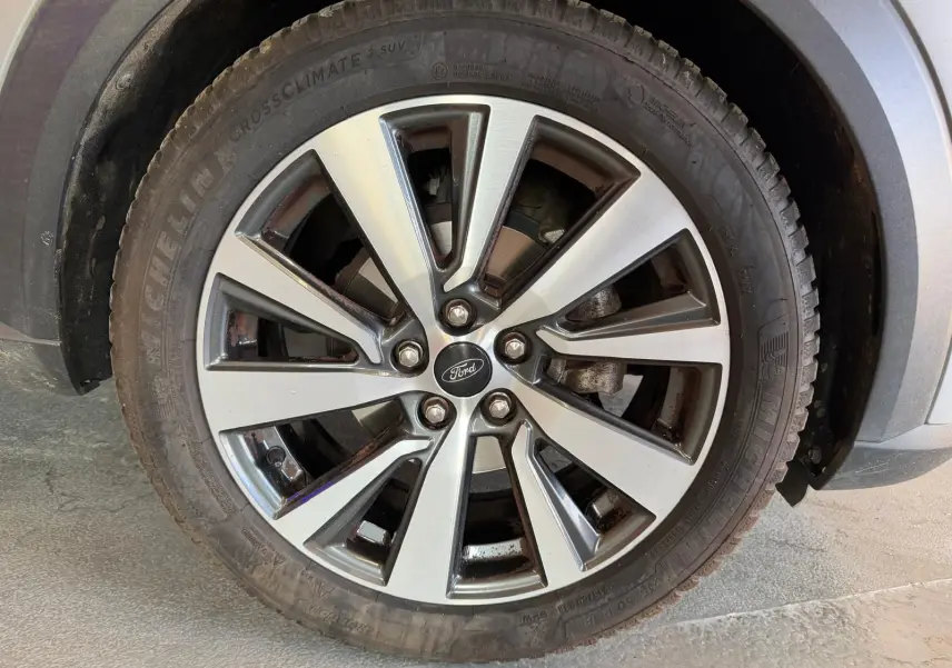 Gros plan sur la jante alliage bicolore du côté avant droit du Ford Puma gris 2021 version Titanium.