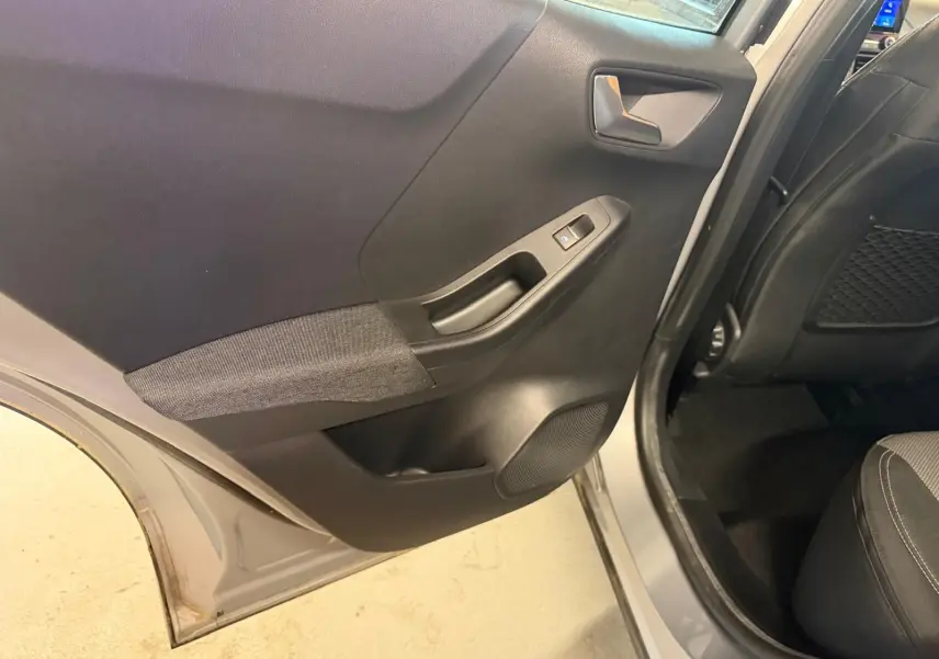 Vue rapprochée de la porte arrière droite grise du Ford Puma 2021, avec garniture noire et tissu gris.
