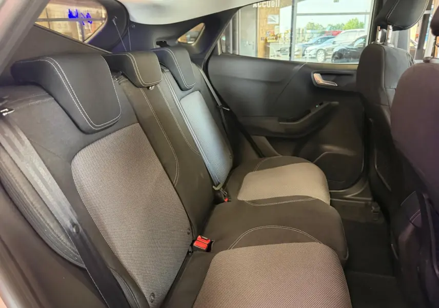 Vue intérieure côté droit des sièges arrière en tissu noir et gris du Ford Puma 2021 gris, avec appuie-têtes et ceintures visibles.