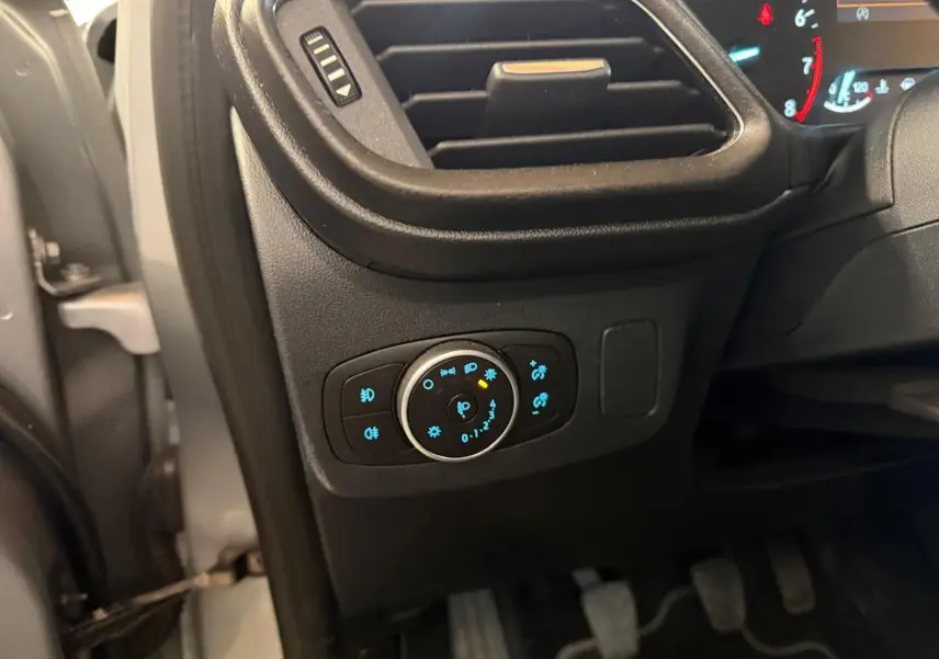 Vue intérieure côté gauche du tableau de bord du Ford Puma gris 2021, avec commandes d'éclairage et pédales visibles.