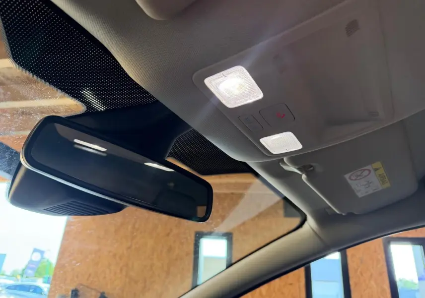 Vue intérieure du rétroviseur central et du plafonnier avec éclairage allumé d'une Ford Puma gris 2021 finition Titanium.