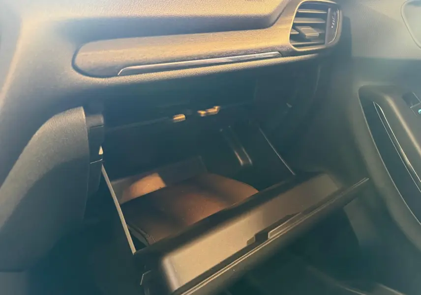 Vue rapprochée de la boîte à gants ouverte côté passager de l’intérieur noir du Ford Puma gris 2021.