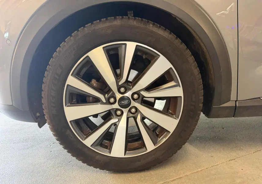 Gros plan sur la roue avant droite d’un Ford Puma gris, mettant en valeur la jante alliage à cinq doubles branches.